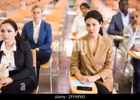 Group of corporate employees attentively listening to business training in conference room Stock Photo