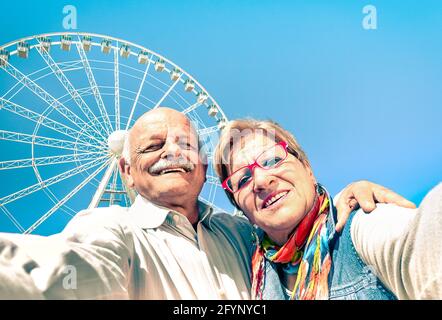 Happy retired senior couple taking selfie at travel around the world - Concept of active playful elderly with mobile phone Stock Photo