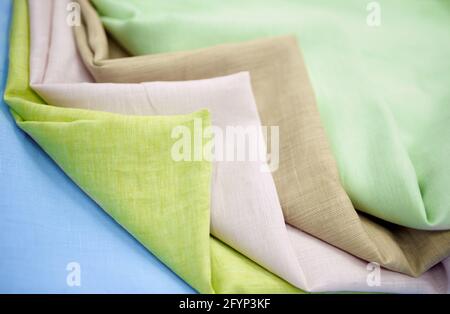 Pack pastel colored linen cloth fabrics in stack. Closeup multicolor towels one on one. Sewing items or tailoring objects concept. High quality horizontal photo Stock Photo