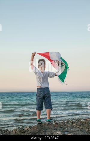 Young boy holding flag of Mexico at the Sea'September 16. Independence Day of Mexico'. Stock Photo