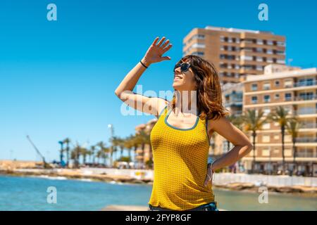 Young woman dressed in yellow enjoying the holidays in the coastal city Stock Photo