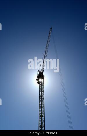 Tower Crane silhouetted against a featureless blue sky, construction work, London, United Kingdom Stock Photo