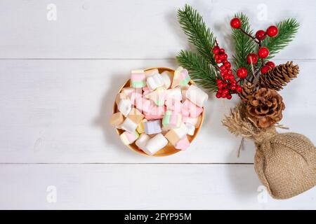 composition of a small Christmas tree and marshmallows on a white wooden background. new year and christmas concept Stock Photo