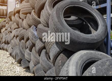 Car tires are stacked in large piles at car repair shop Stock Photo