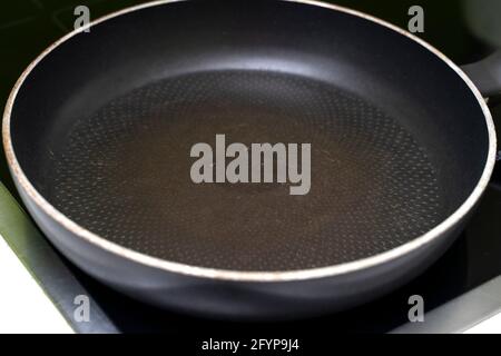 old empty non-stick frying pan. the coating is damaged. Stock Photo