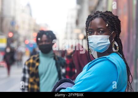 Black couple in the city. With masks. Stock Photo