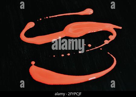 Closeup of red paint drips and splashes isolated on black background Stock Photo