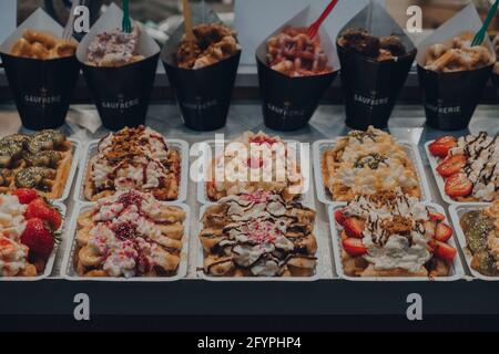 Brussels, Belgium - August 17, 2019: Belgian waffles with different toppings on sale as a La Gaufrerie cafe in Brussels, the capital of Belgium and a Stock Photo