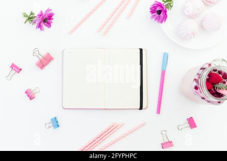 Berries smoothie with straws, marshmallow and pink anemones with paper pages of diary on white. Flat lay. Stock Photo