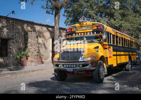 Bright yellow Guatemalan 'chicken bus' (local bus serving the small towns near Antigua, Guatemala) Stock Photo