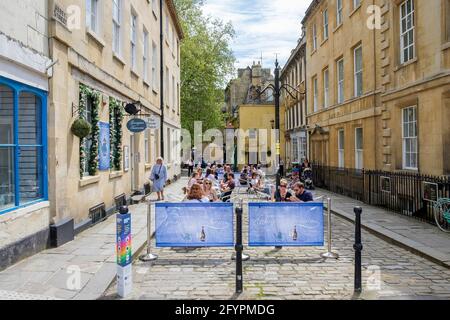 Bath, Somerset, UK. 29th May, 2021. Customers are pictured sitting outside and enjoying an afternnon drink in the centre of Bath. Crowds of shoppers filled the streets as people made the most of the bank holiday weekend sunshine. Credit: Lynchpics/Alamy Live News Stock Photo