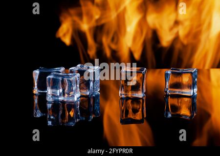 five ice cubes on a black background, in the background flames Stock Photo