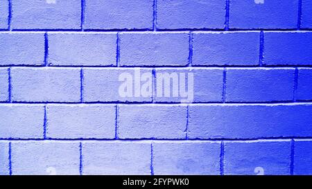 Blue background from brick blocks. Texture of a wall made of large bricks. Copy space. The neon wall is blue. Stock Photo