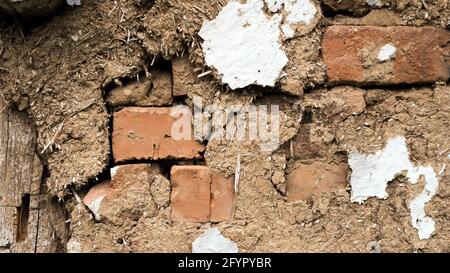 Wooden wall made of clay and straw. Antique texture. Red brick background with clay. Stock Photo