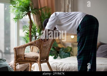 African young man working out, practicing yoga, standing in Ardha Uttanasana Stock Photo