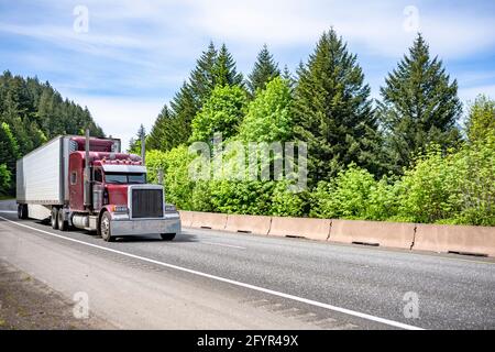 Burgundy classic big rig semi truck tractor with chrome accessories and vertical exhaust pipes transporting cargo in same style refrigerator semi trai Stock Photo