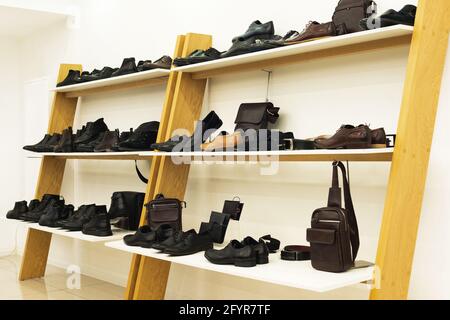 mens boots and accessoires on elegant wooden rack in boutique Stock Photo