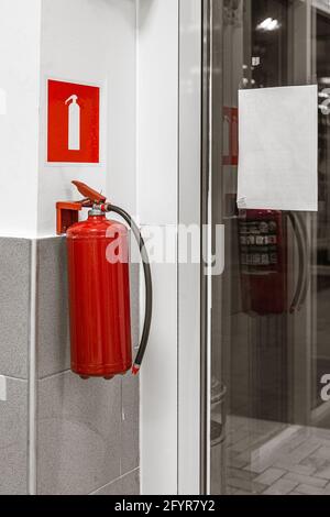 fire extinguisher and sign on wall Stock Photo