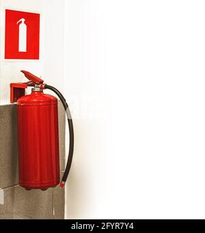 fire extinguisher and sign on white wall Stock Photo