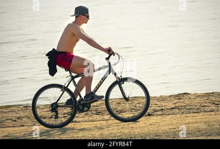 2019: biker rides along beach a russian mountain bicycle Stels-630 Stock Photo