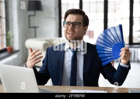 Exhausted male office employee suffering from heat, hot stuffy air Stock Photo