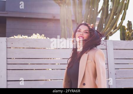 Beautiful brunette tossing her hair while walking on the street. Stock Photo