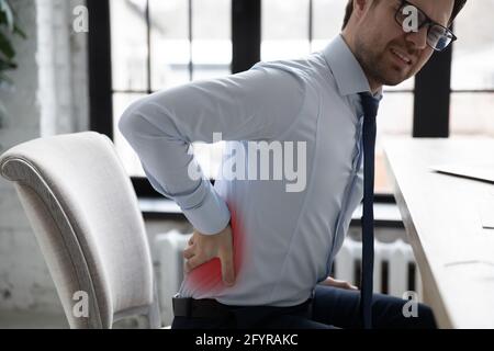 Unhappy office worker suffering from back pain attack Stock Photo