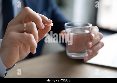 Manager, employee, worker taking pills, painkillers, antibiotics Stock Photo