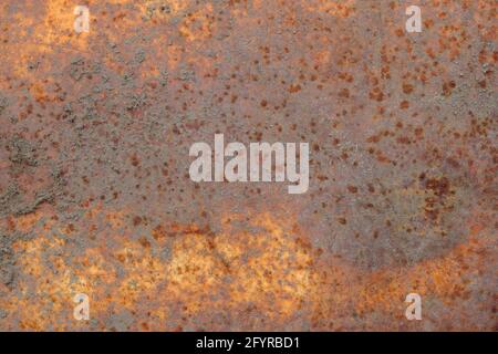 The texture of a rusty metal surface covered with dirt and multicolored rust. Stock Photo