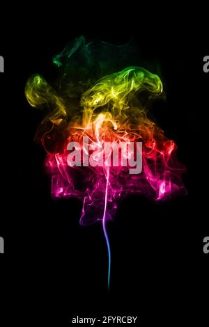 A colorful smoke spiral pattern in rainbow colours on black background. Stock Photo