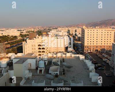 The low-rise, beige colored skyline of Muscat in late afternoon sun. In Oman. Stock Photo