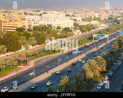 The low-rise, beige colored skyline of Muscat and roadways, streets in late afternoon sun. In Oman. Stock Photo