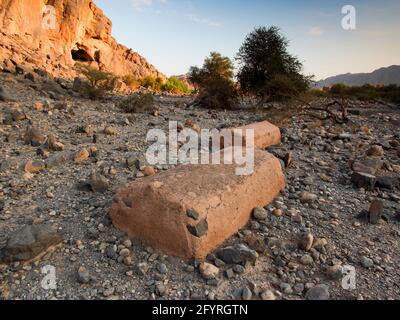 A couple of old, unmarked graves sit in a rocky desert area in Tanuf. In Oman. Stock Photo