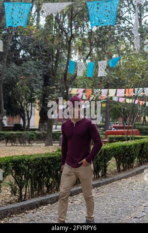 Young hispanic man wearing a beanie walking in the park Stock Photo