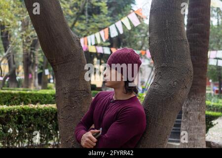 Young hispanic and muscular man with beanie looking at the distance Stock Photo