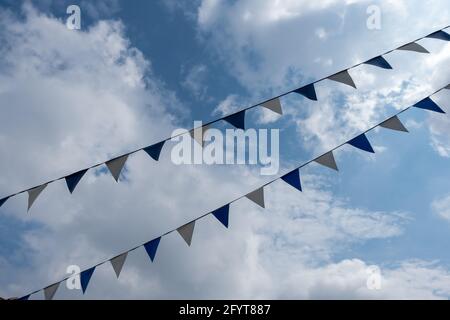 triangle flags hanging in front of cloudy sky background Stock Photo