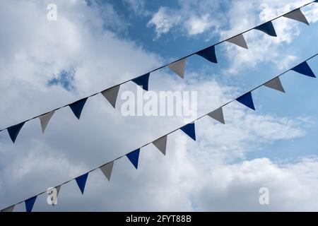 triangle flags hanging in front of cloudy sky background Stock Photo