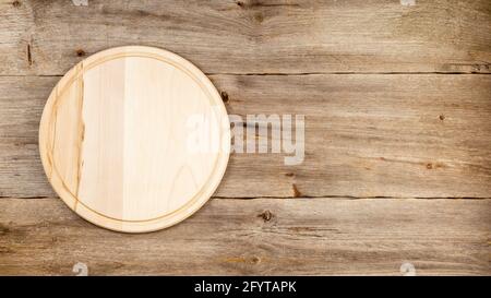 Background with wooden pizza board over grunge rustic background Stock Photo