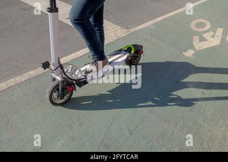 Lifestyle a person riding an electric scooter on the bike lane Stock Photo