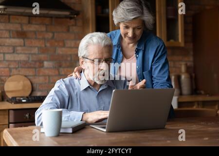 Married mature couple buying together on internet using laptop Stock Photo