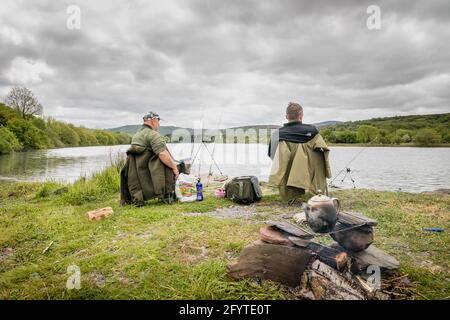 Ballingeary, Cork, Ireland. 29th June, 2021. Friends Pawel Szurek and Grzegorz Sepiol having a relaxing afternoon fishing for Pike on on overcast warm day at Lough Allua outside Ballingeary, Co. Cork, Ireland. - Credit; David Creedon / Alamy Live News Stock Photo