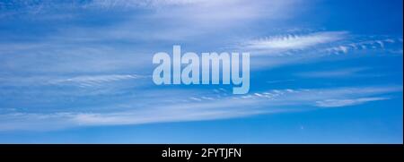 Panorama of blue sky with white clouds floating in the sky on a clear sunny warm day, summer sky landscape with blurred abstract clouds. Stock Photo