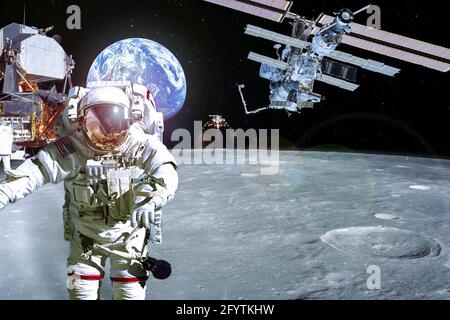 Lunar exploration concept - American astronaut in the foreground with spaceships and the Earth in the background. Elements of this image furnished by Stock Photo