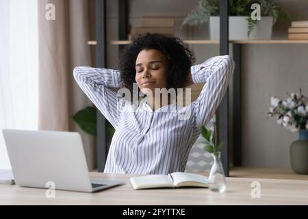 Calm biracial woman relax at desk at home office Stock Photo