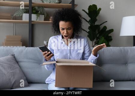 Unhappy biracial woman frustrated with bad quality order Stock Photo