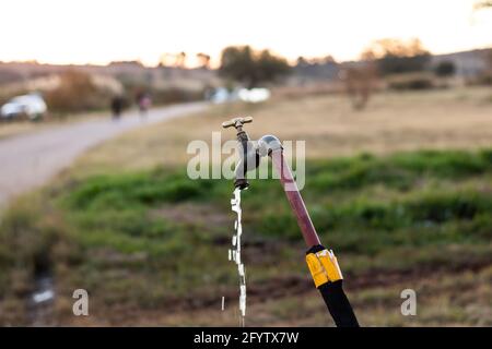 Open water tap outside in nature. Water tap open flowing of water. Stock Photo