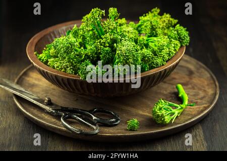 Organic Broccolini (bimi) in bowl on wooden background Stock Photo