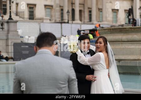 An Asian couple has their wedding photos taken in Trafalgar Square, London, UK Stock Photo