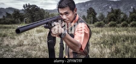 Man taking aim shotgun. Close up, Panoramic photograph Stock Photo