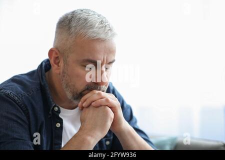 Sad elderly man leaning on hands, closeup portrait Stock Photo